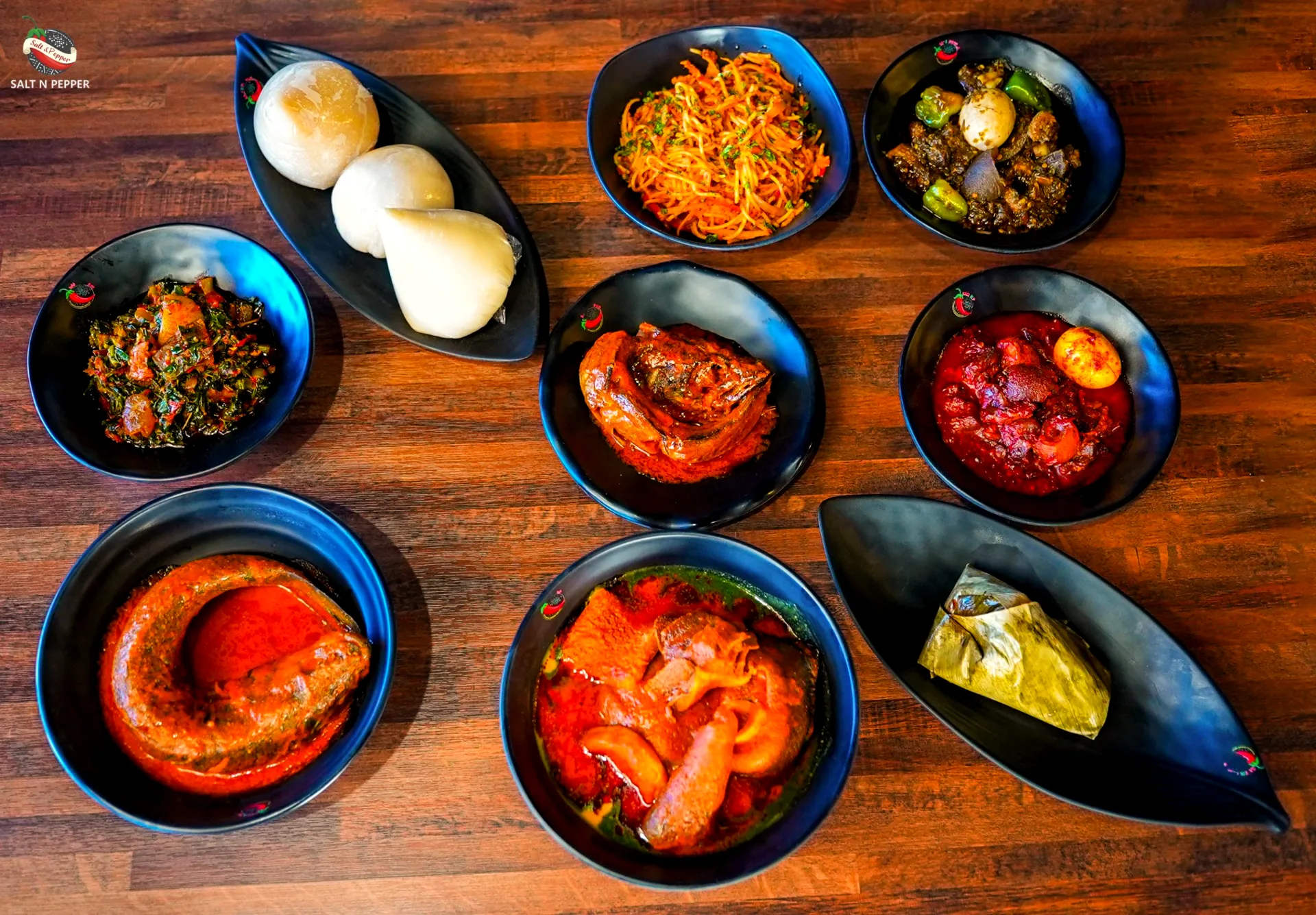 A table of Nigerian dishes: amala, pounded yam, jollof, stews and soups